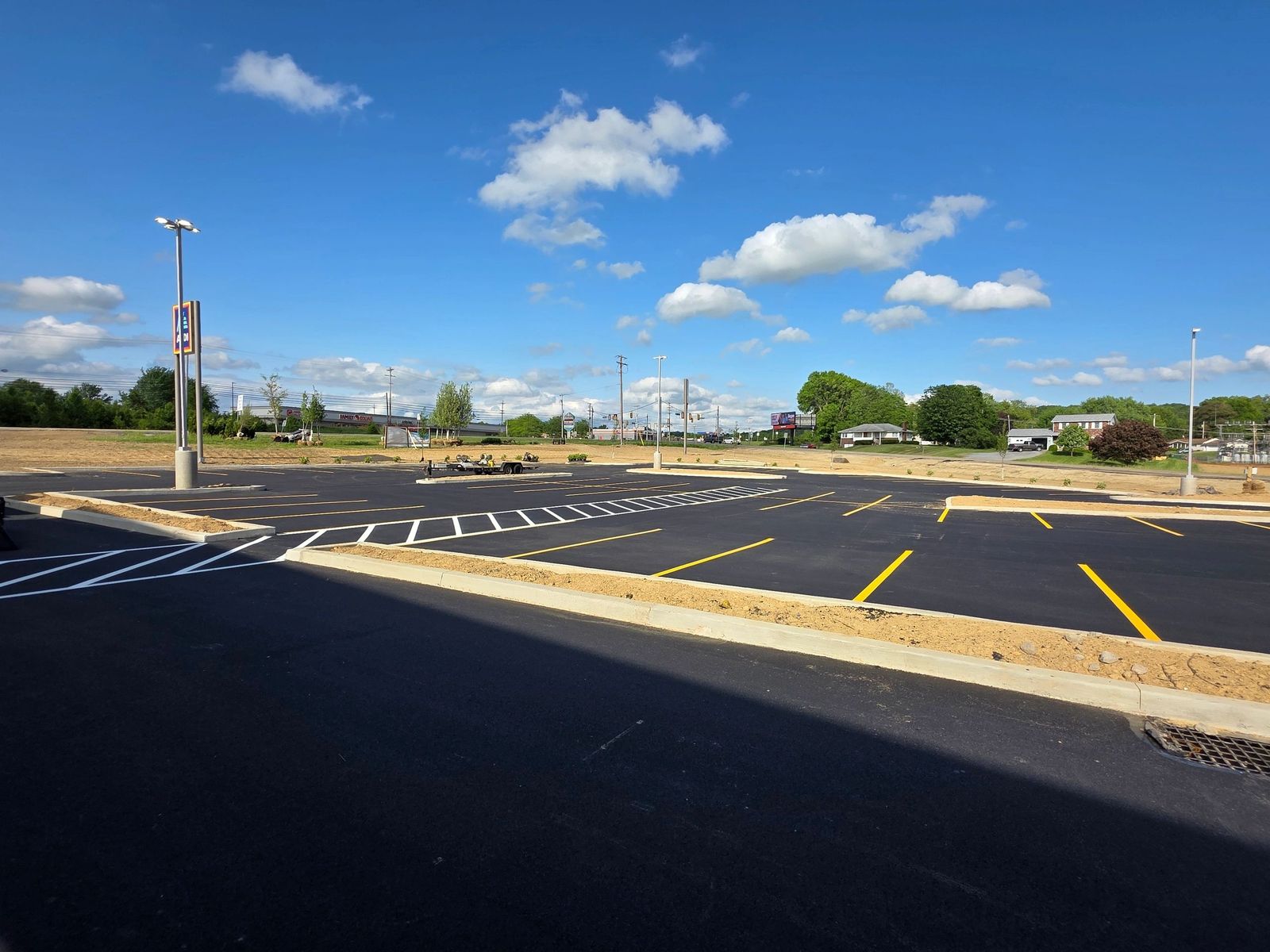 Yellow parking-stall lines and white hatch on black asphalt, a job photo from Paint N Parking Lots LLC