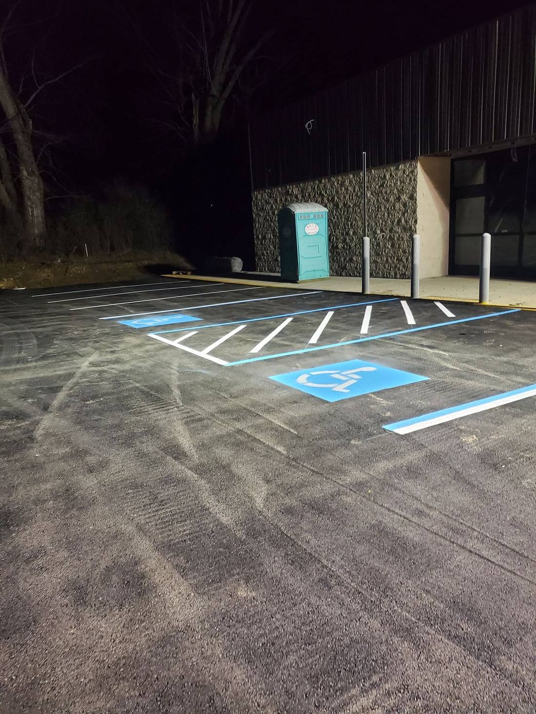 Blue ADA stalls and white hatch photographed at night